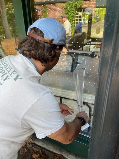 A person applying dot stickers to a window.